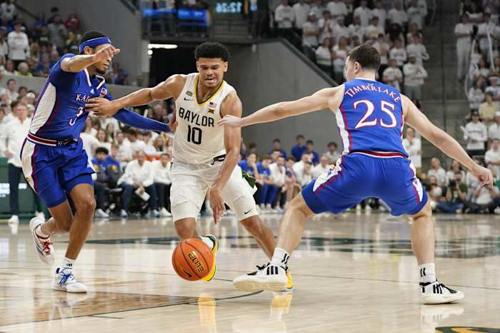 Mar 2, 2024; Waco, Texas, USA; Baylor Bears guard RayJ Dennis (10) splits the defense of Kansas Jayhawks guard Dajuan Harris Jr. (3) and guard Nicolas Timberlake (25) during the second half at Paul and Alejandra Foster Pavilion.